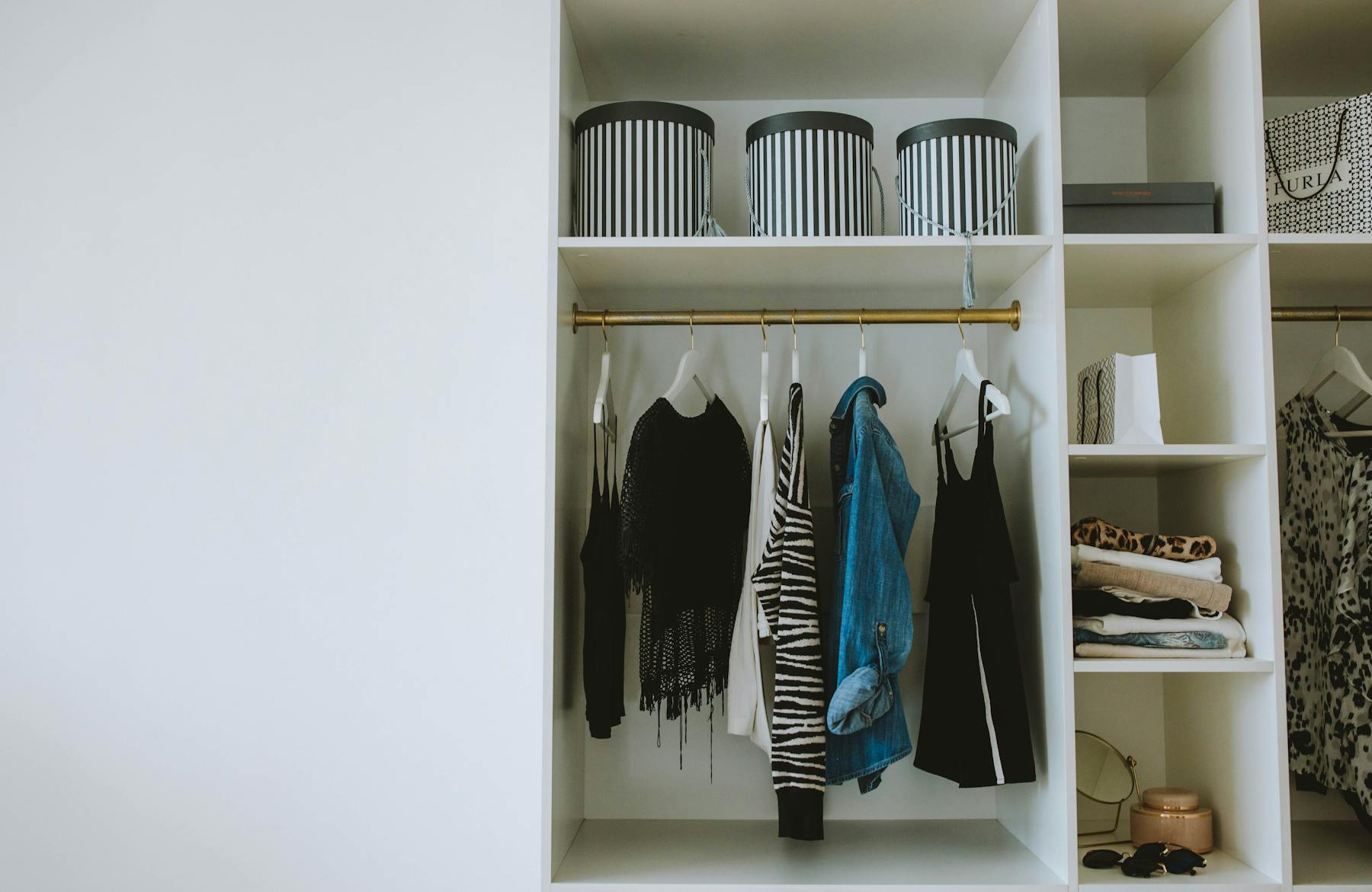 Blue and Black Clothes Hanging in White Wooden Cabinet